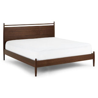 The Legacy Panel Bed as a centerpiece in a spacious, naturally lit minimalist bedroom."